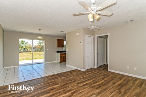 A spacious room with a ceiling fan and wooden flooring.