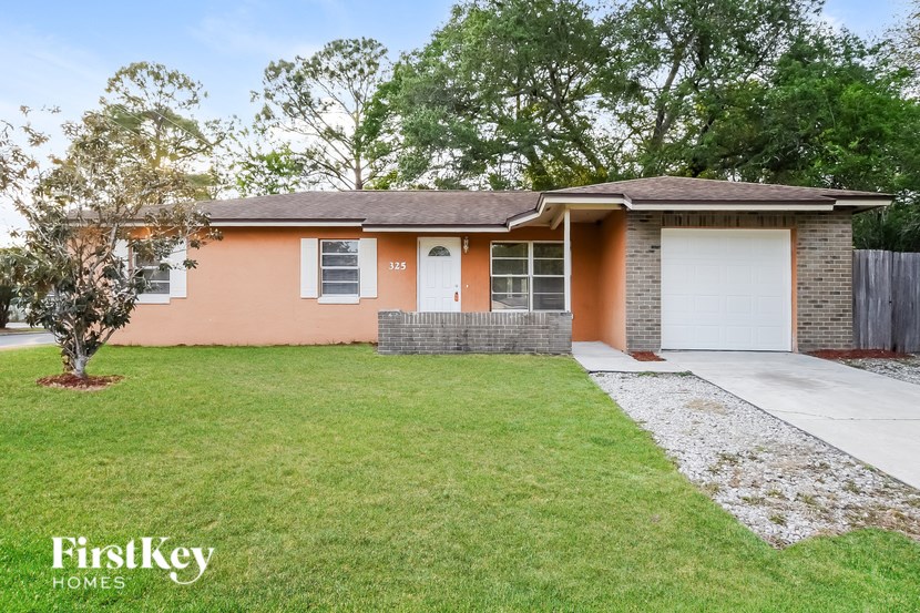 A house with a brown roof and a white garage door is for sale.