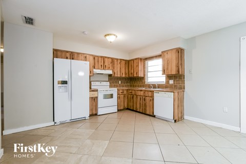 A kitchen with wooden cabinets and white appliances.