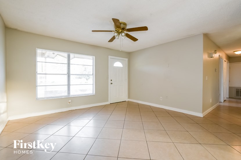 A spacious room with a ceiling fan and tiled flooring.