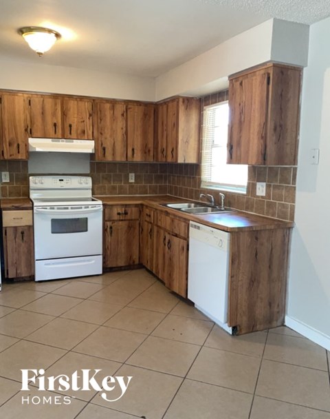 A kitchen with wooden cabinets and a white dishwasher.