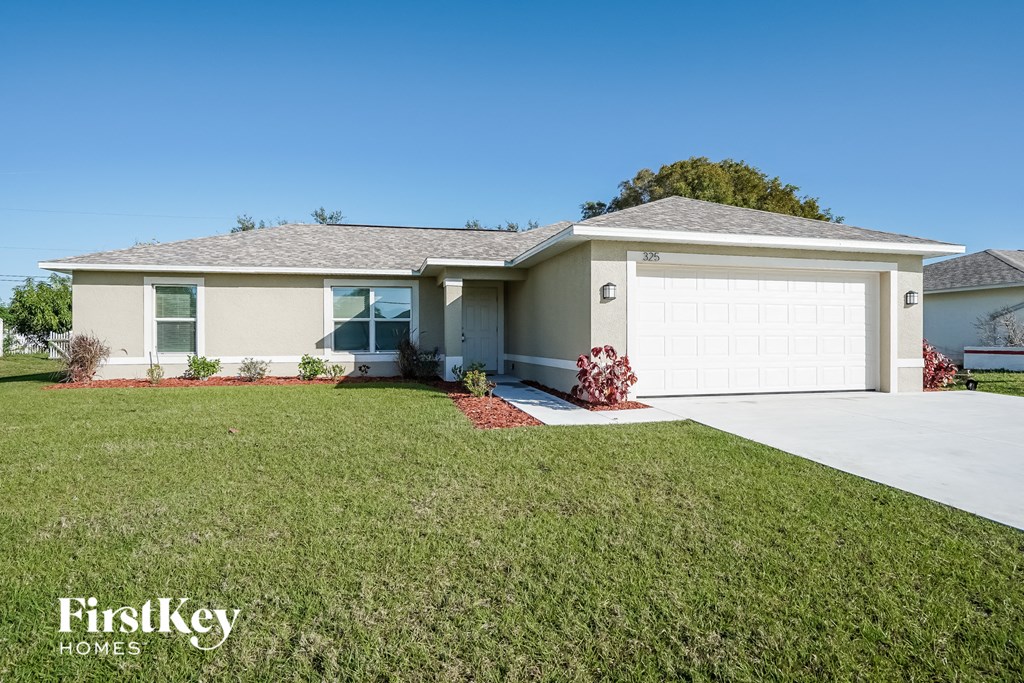 a beige house with a lawn and a white garage door