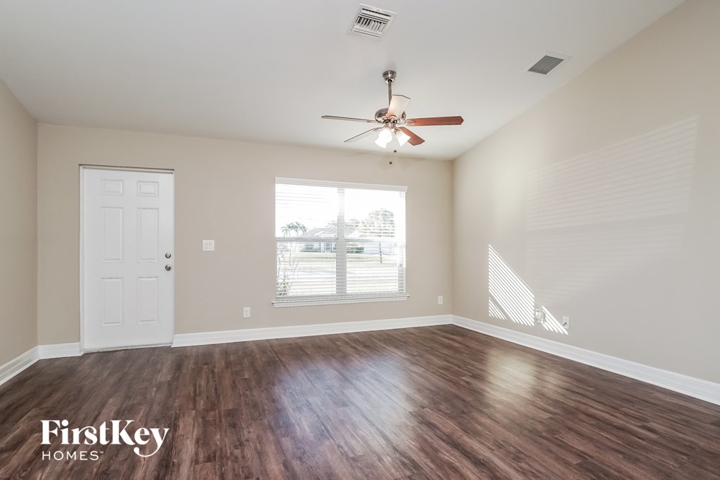 the living room of an empty house with a ceiling fan