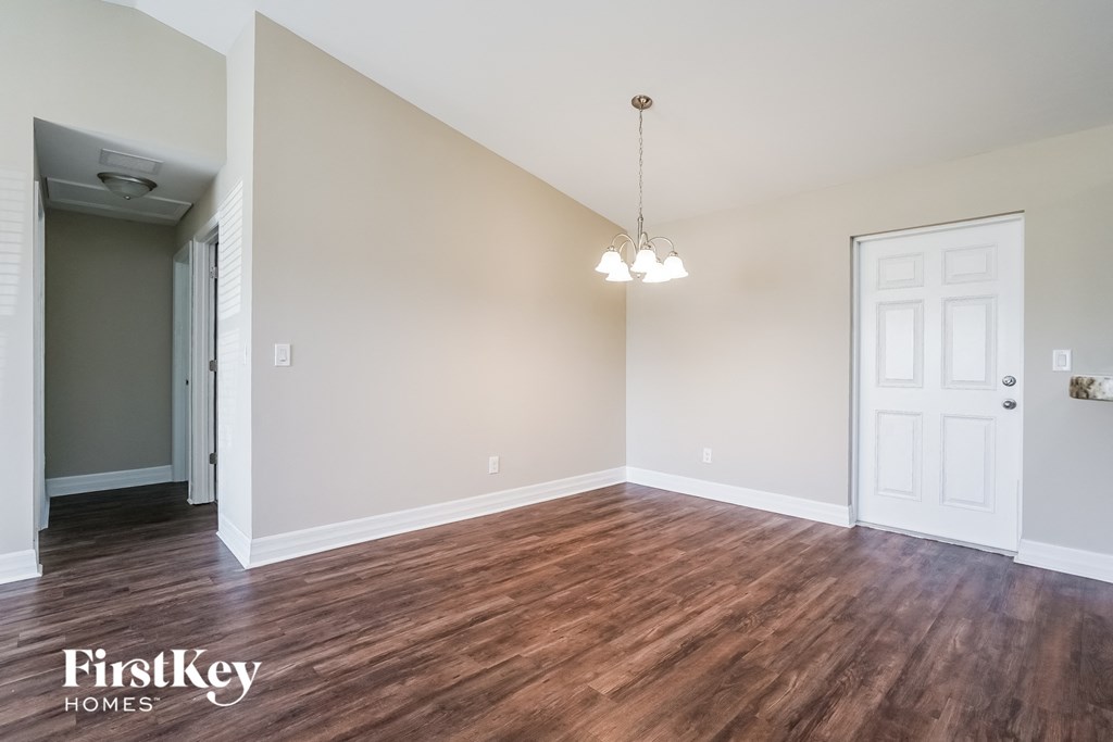 an empty living room with wood flooring and a white door