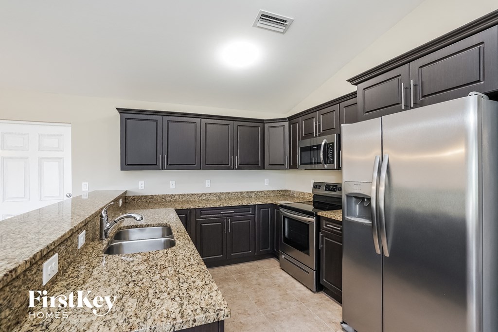 a kitchen with stainless steel appliances and granite counter tops