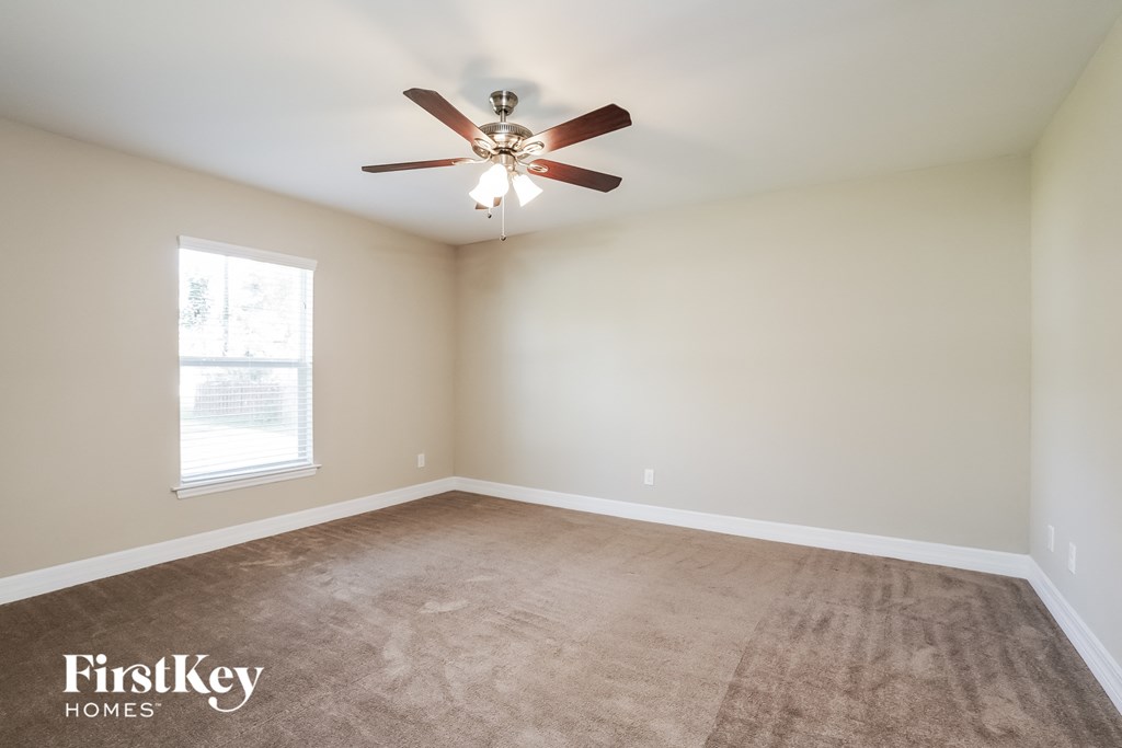 an empty room with a ceiling fan and a window