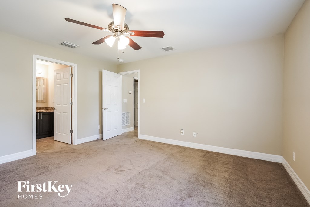 a living room with carpet and a ceiling fan