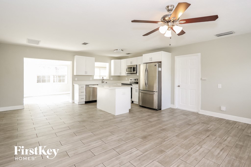an open kitchen and living room with a ceiling fan
