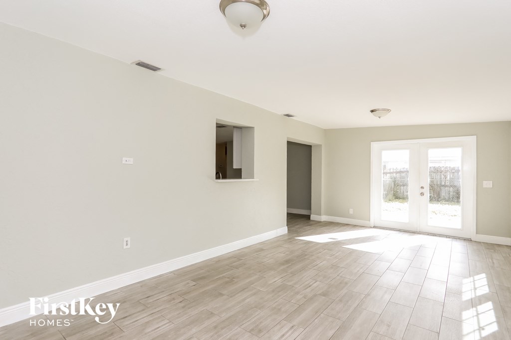 an empty living room with white walls and wood floors