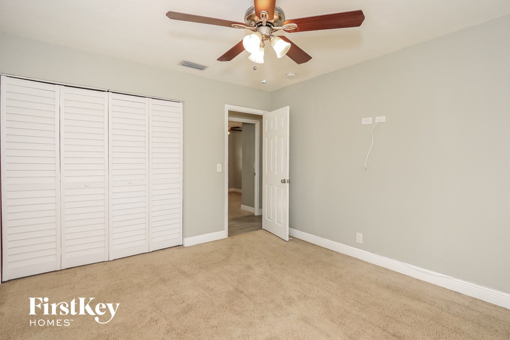 a bedroom with a ceiling fan and a closet