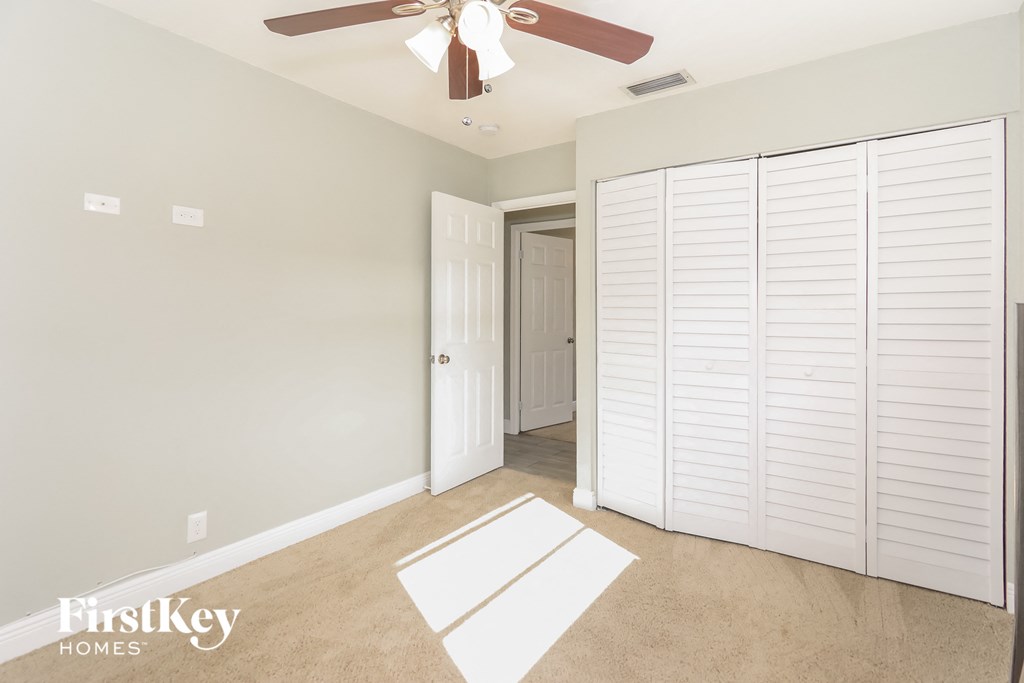 a bedroom with a closet and a ceiling fan