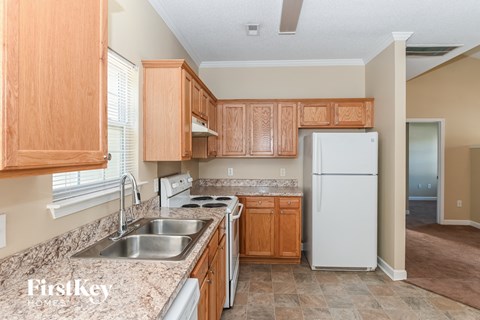A kitchen with wooden cabinets and a white refrigerator.