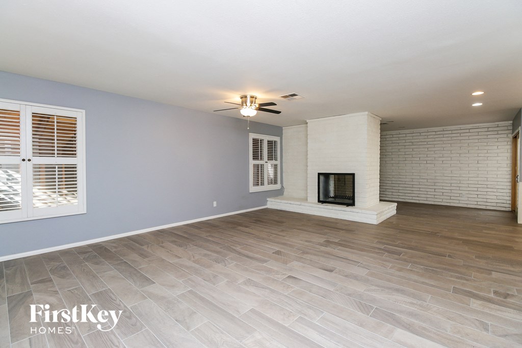 a living room with a fireplace and a ceiling fan