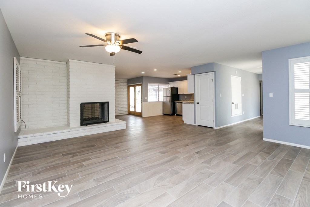 a living room with a fireplace and a ceiling fan