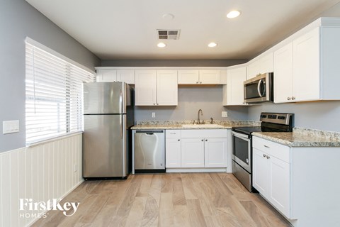 a kitchen with white cabinets and stainless steel appliances