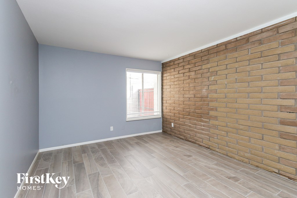the living room with brick wall and wood flooring
