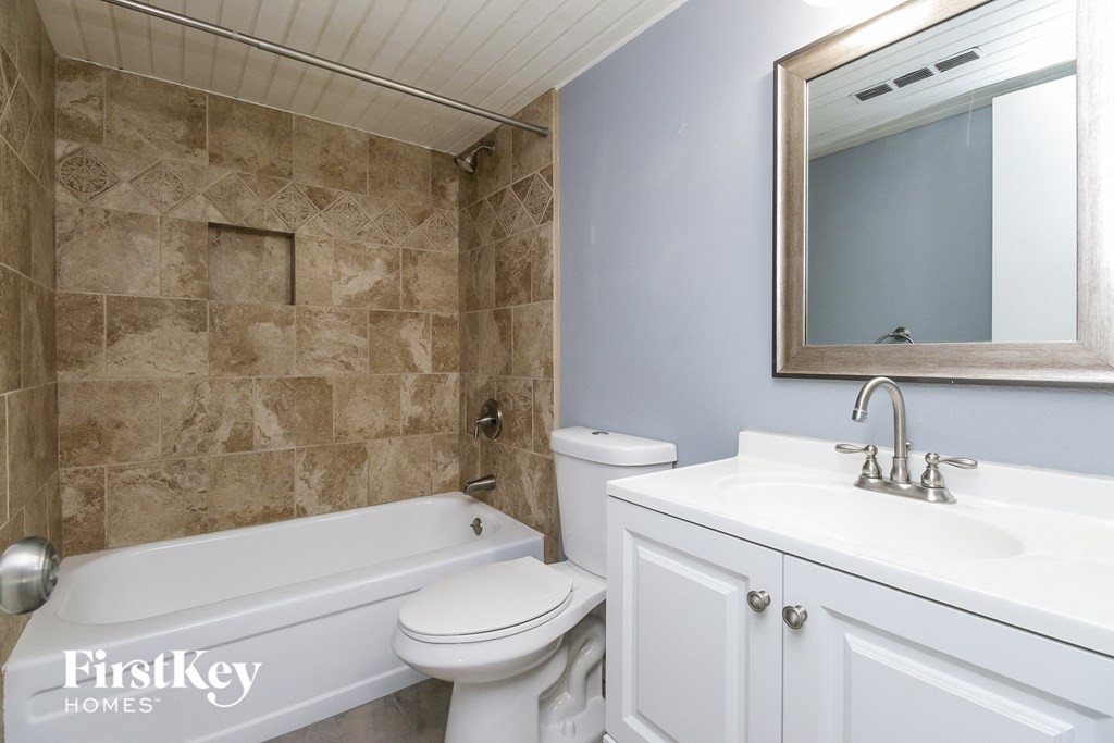 a bathroom with a sink toilet and tub and a mirror