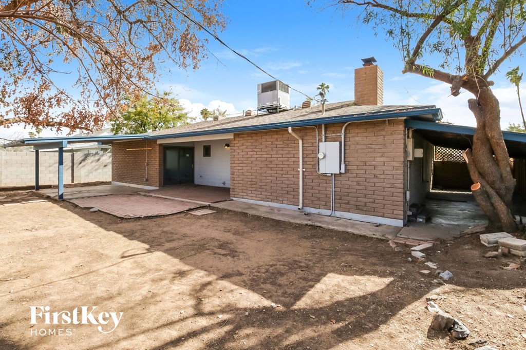 a small brick house with a garage and a tree