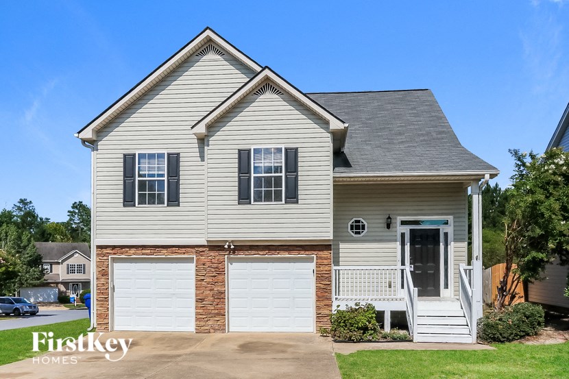 A house with a grey roof and a white garage door.