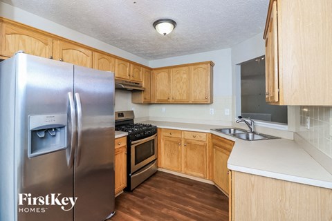 A kitchen with wooden cabinets and a stainless steel refrigerator.