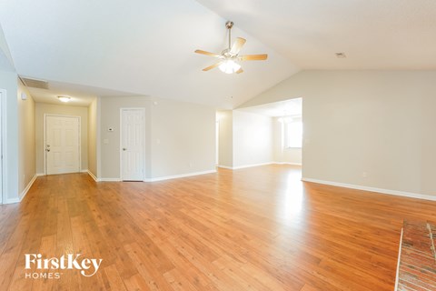 the living room and dining room with wood flooring and a ceiling fan