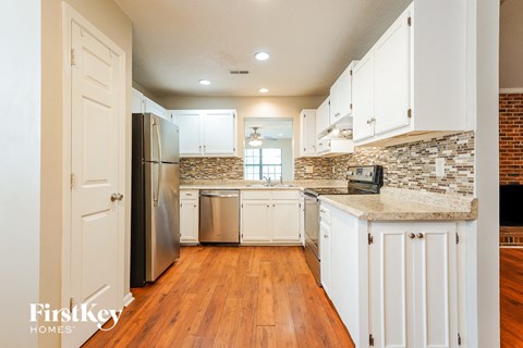 a kitchen with white cabinets and a stainless steel refrigerator