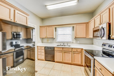A kitchen with wooden cabinets and a stove top oven.