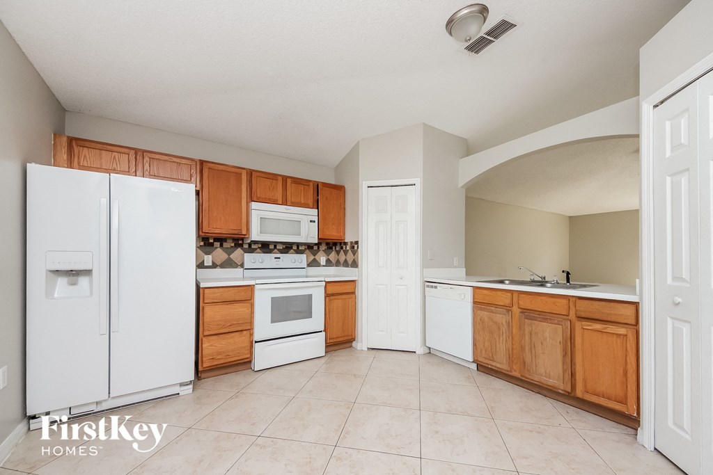 a kitchen with white appliances and wooden cabinets