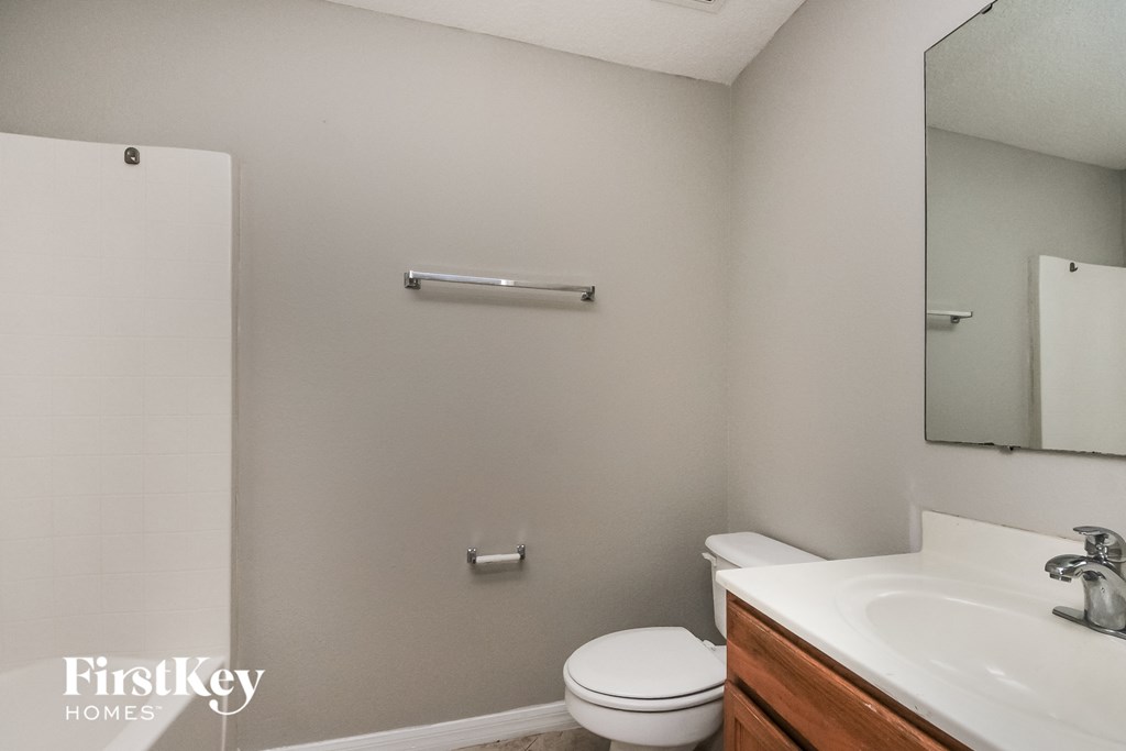 a bathroom with a sink toilet and a mirror