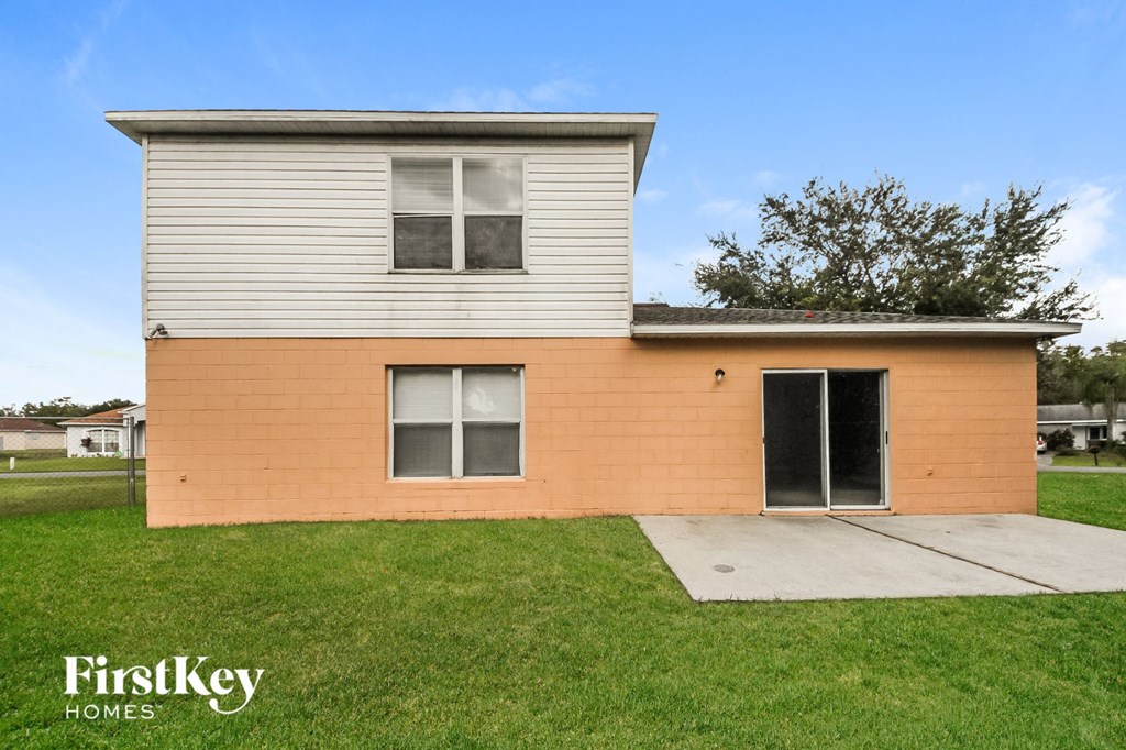 the front of a small house with a yard and a sidewalk