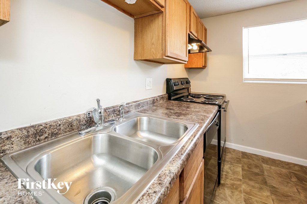 a kitchen with a sink and a stove and a window