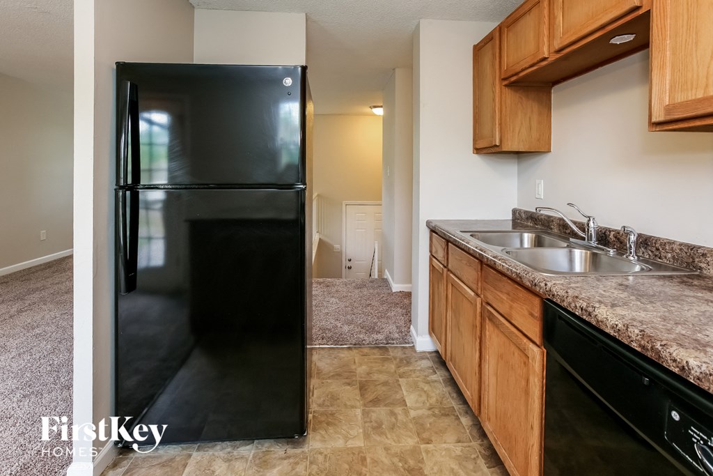 a kitchen with a black refrigerator and a sink
