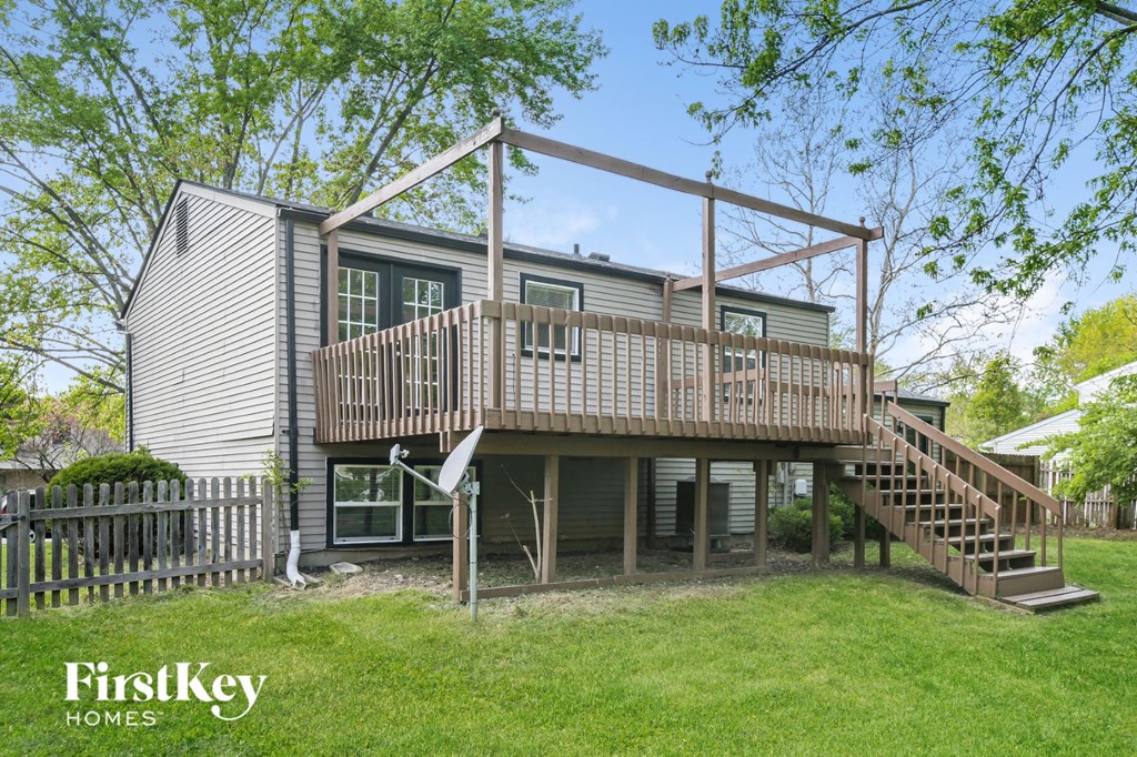 a house with a deck on top of a yard