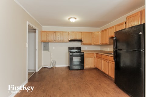 A kitchen with wooden cabinets and black appliances.