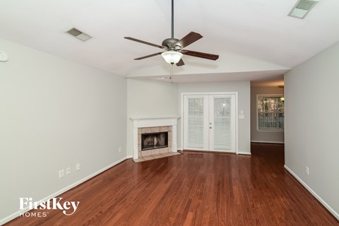 a living room with a ceiling fan and a fireplace