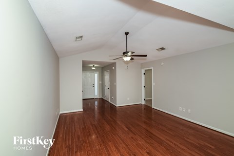a living room with wood floors and a ceiling fan