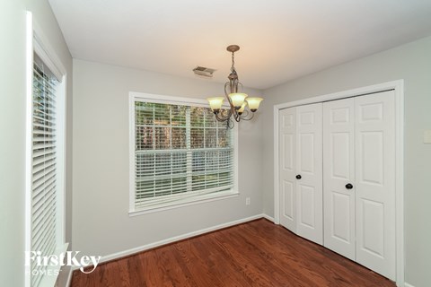 a bedroom with a large window and a door to a closet