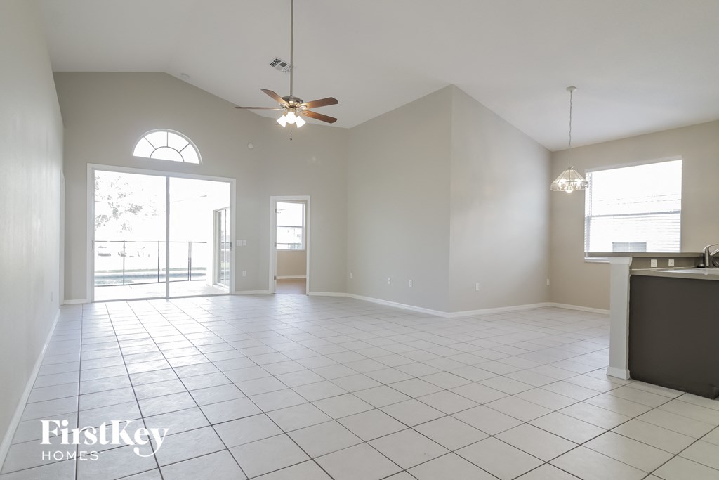 an empty kitchen and living room with a ceiling fan