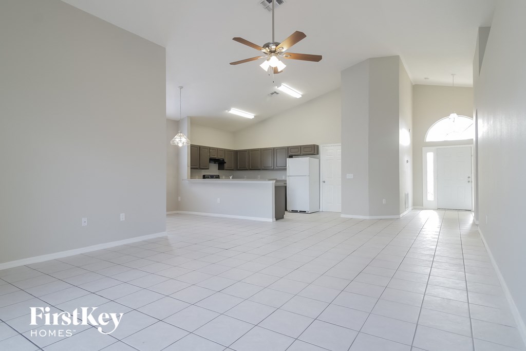 an empty kitchen and living room with a ceiling fan