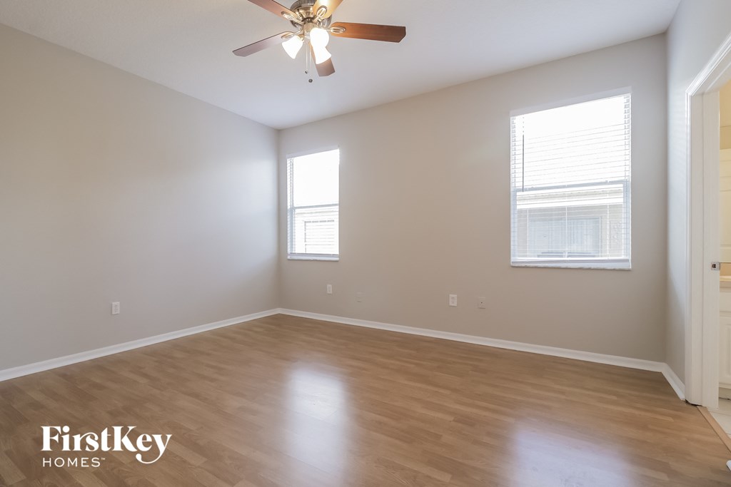 a living room with wood floors and a ceiling fan