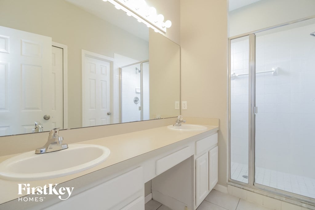 a bathroom with two sinks and a large mirror