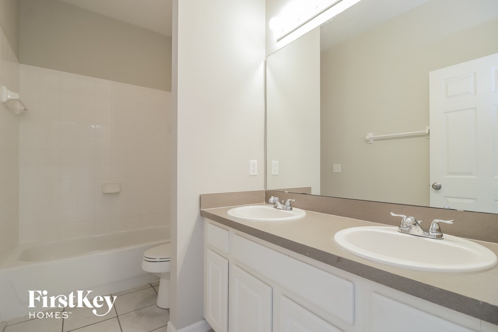 a white bathroom with two sinks and a mirror
