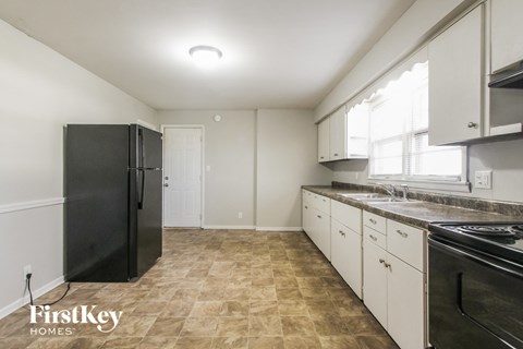 a kitchen with white cabinets and black appliances and a black refrigerator