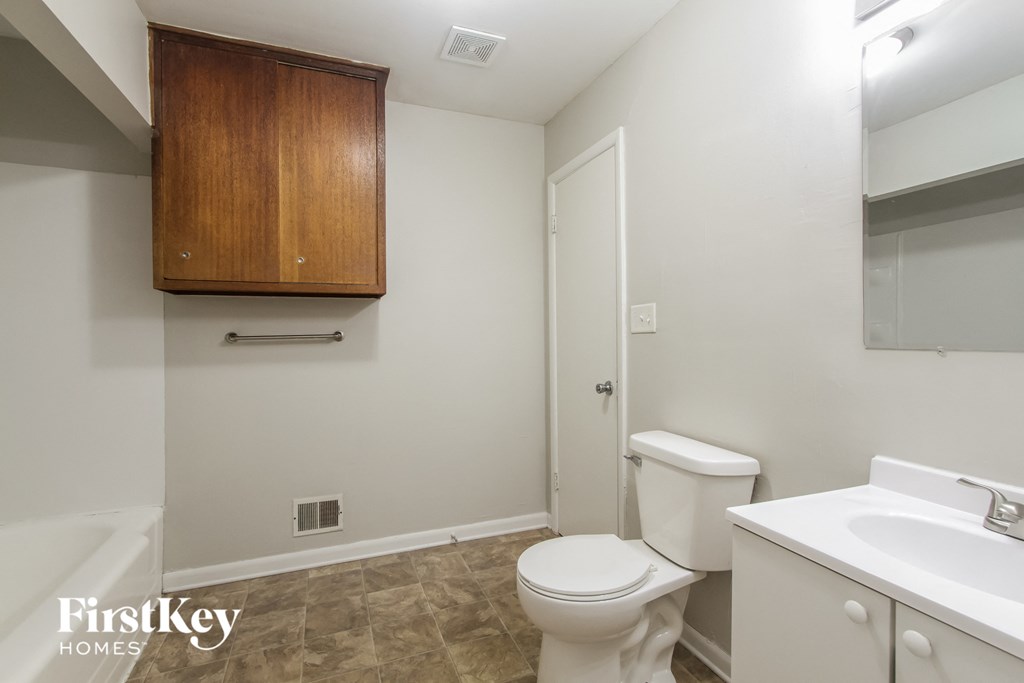 a bathroom with a toilet and a sink and a mirror