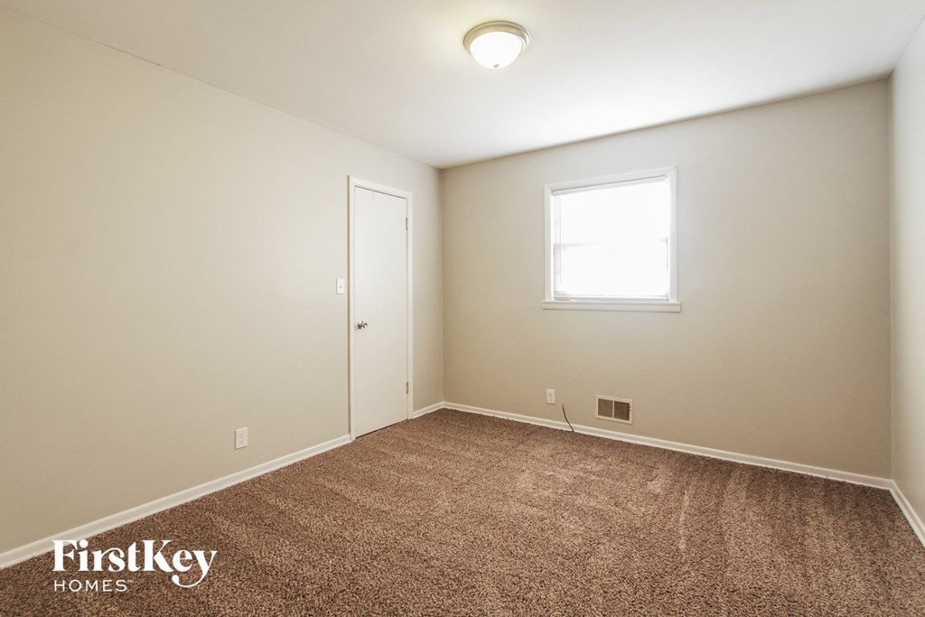 a bedroom with a carpeted floor and a window