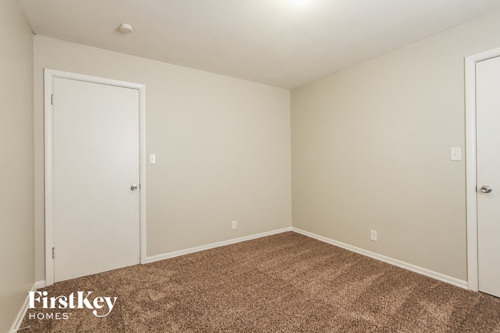 a bedroom with a carpeted floor and white doors