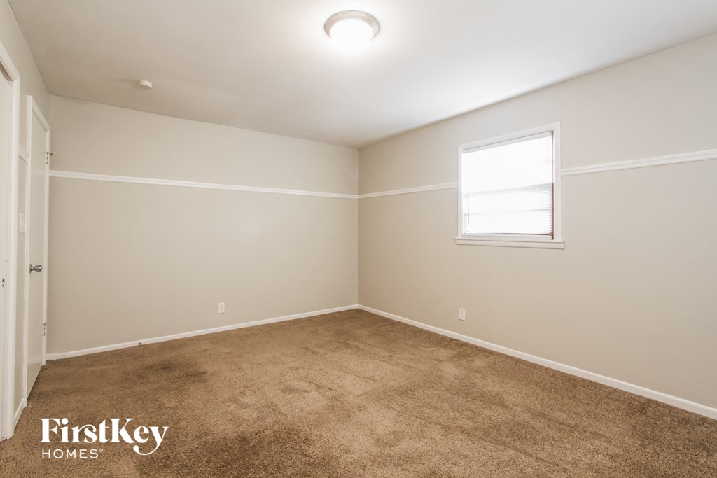 a empty room with carpet and a window