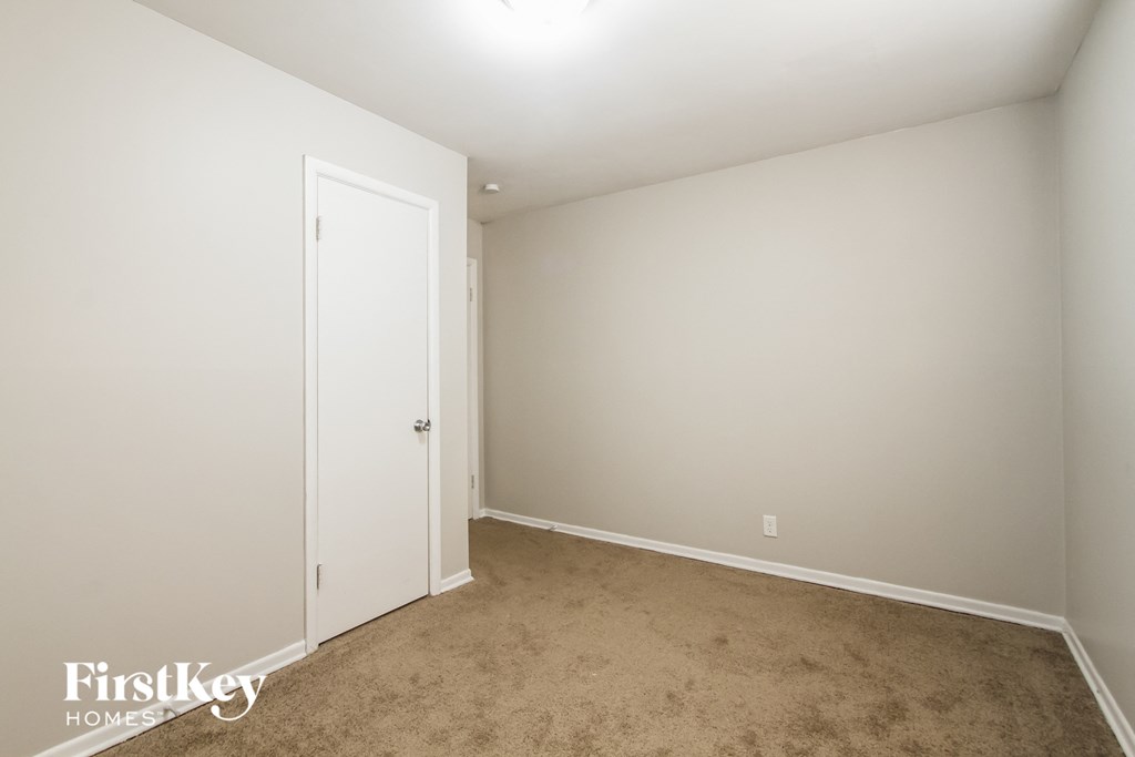 a bedroom with a carpeted floor and a white door