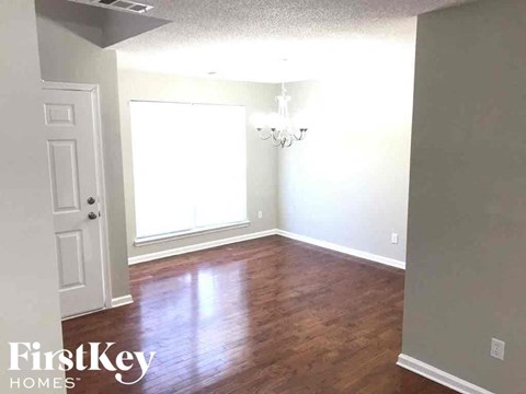 an empty living room with wood floors and a white door