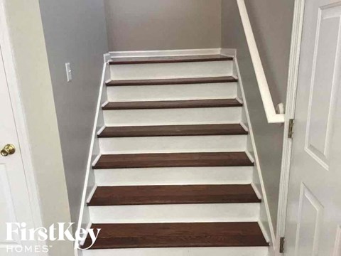 a set of stairs in a home with white and wooden treads